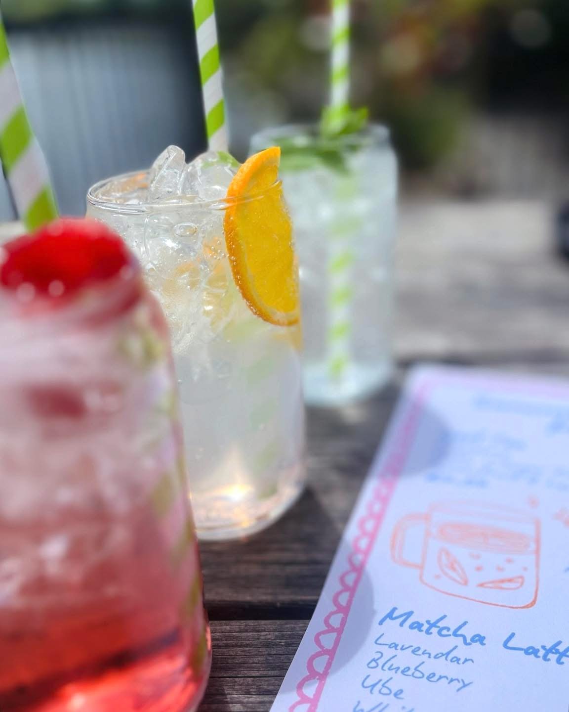 Iced soft drinks with citrus garnish on an outdoor table
