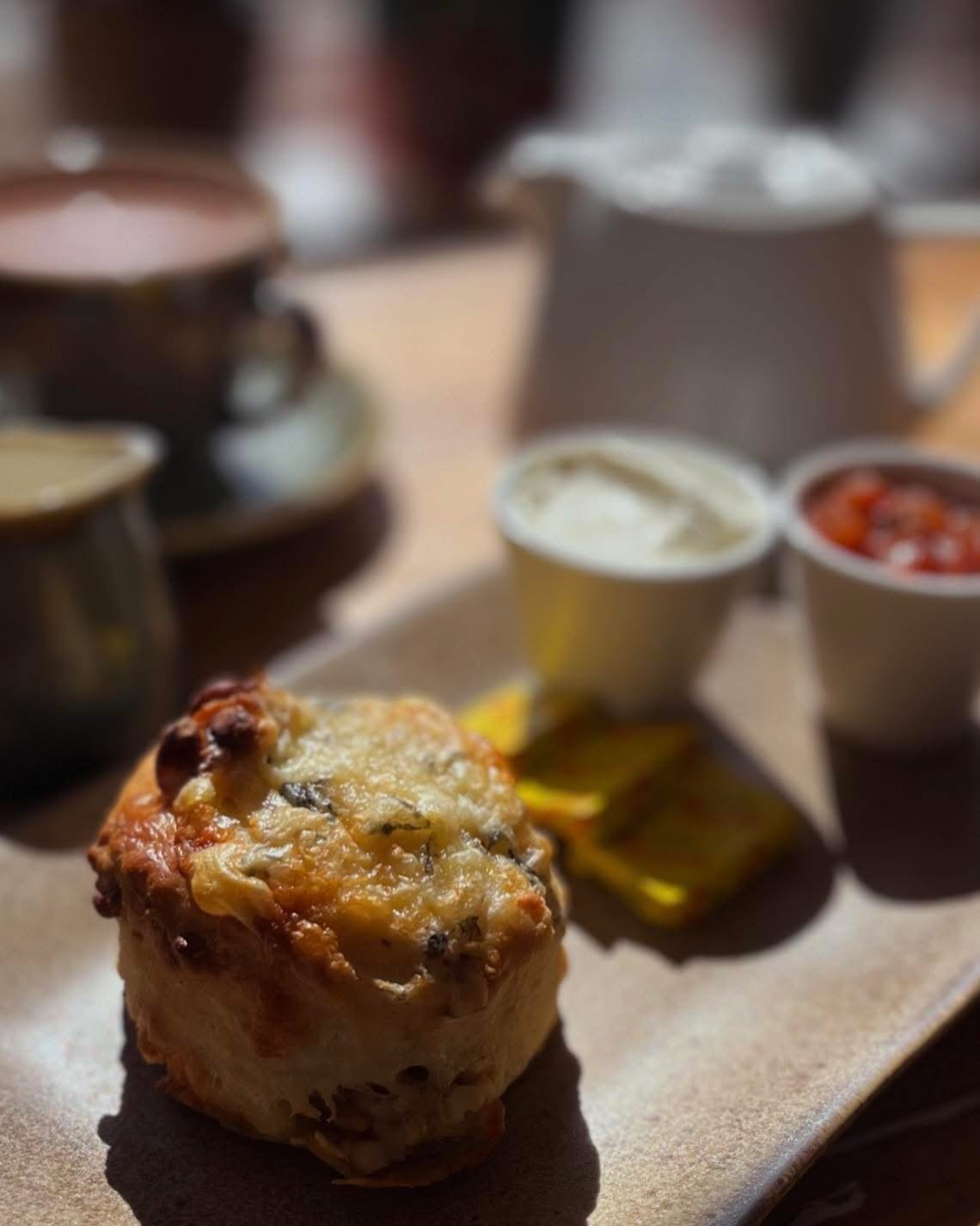 A cheese scone served with butter and jam