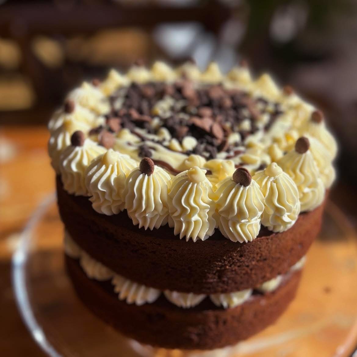 A chocolate layer cake with cream swirls