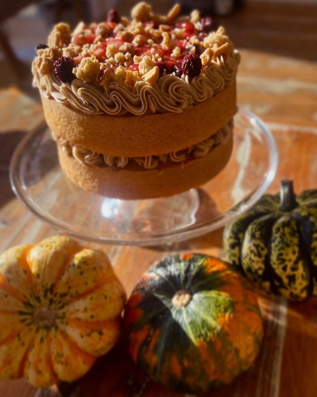 A spiced sponge cake on a stand with seasonal decoration