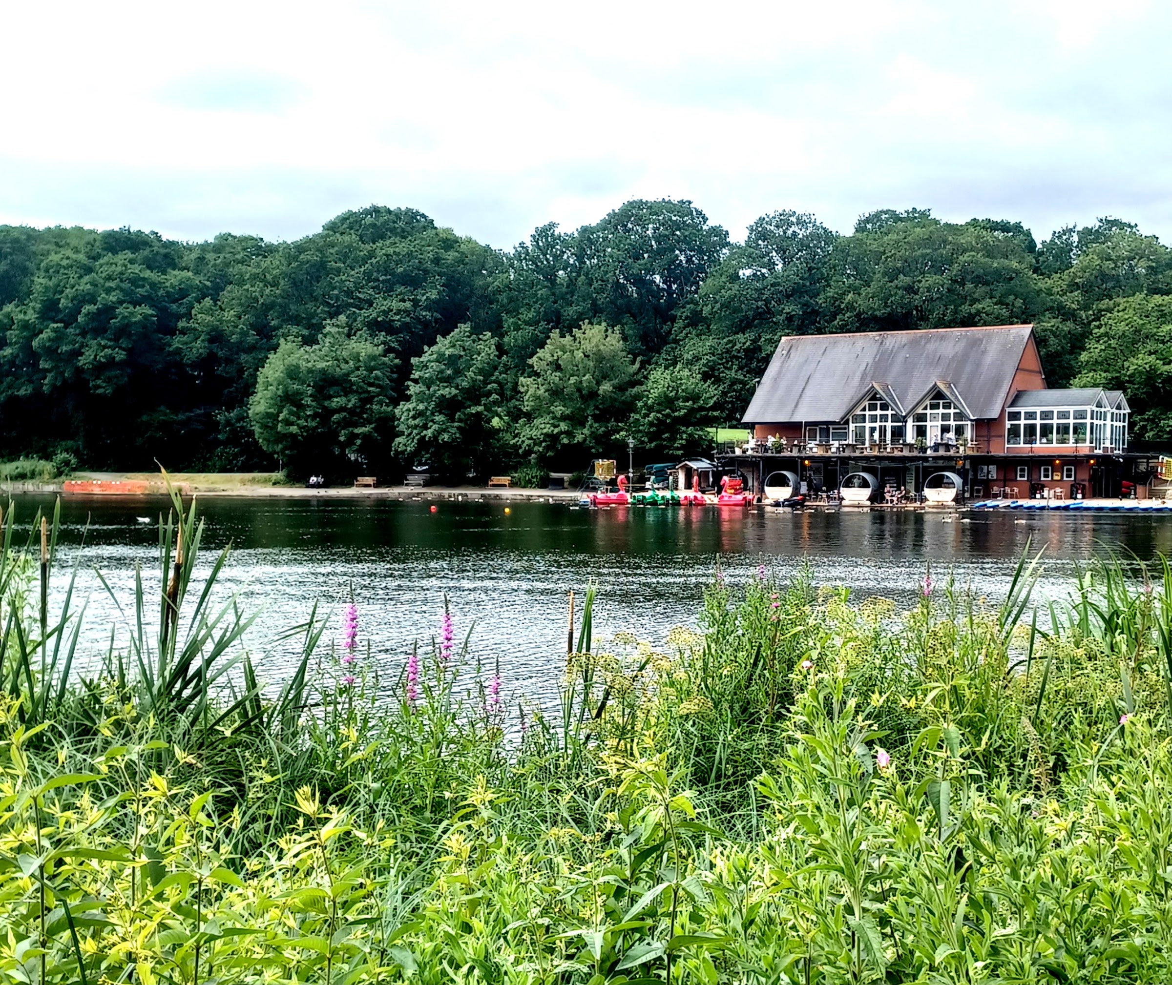 Lakeside Cafe's building on Llandrindod Wells' boating lake, surrounded by wooded hillside